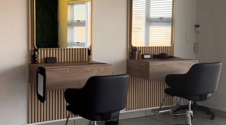 Modern styling stations at Just Glow Hair Studio, Cape Town, Western Cape, ZA, with sleek black chairs.