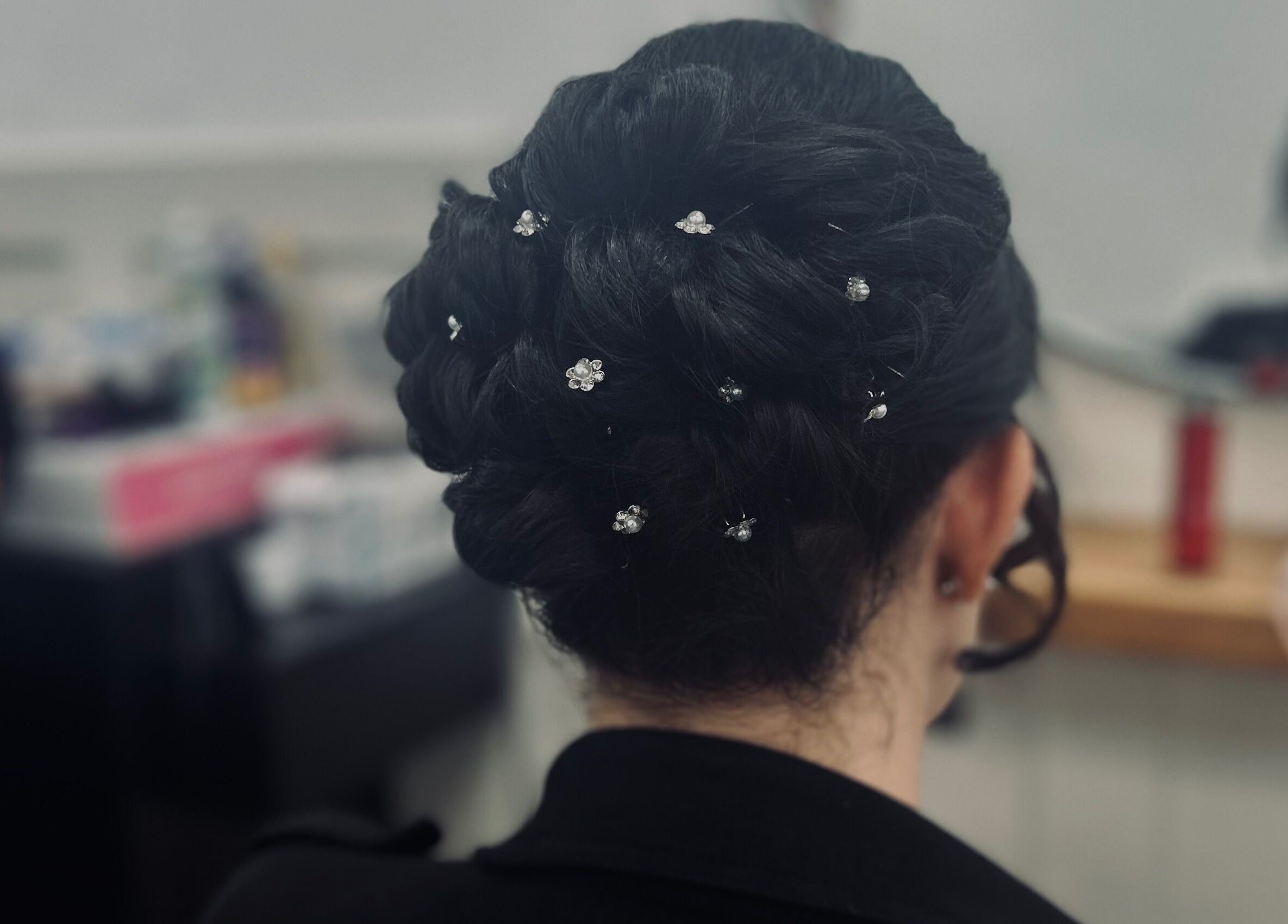 Intricate bridal updo with floral pins at Styled By Tee Swales, Hartlepool, England, GB.