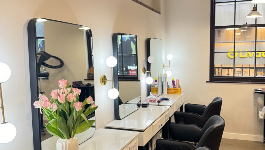 Салон красоты Anastasiia BeautyHair в Лондоне с элегантными зеркалами и цветами.