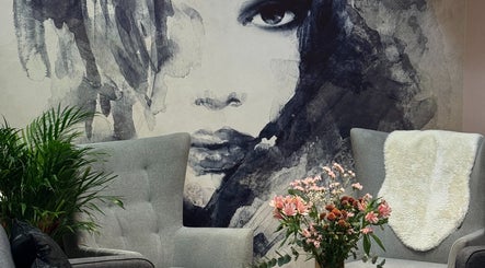 Elegantly decorated seating area in HAIRCULT, London, England, GB featuring a striking face mural.