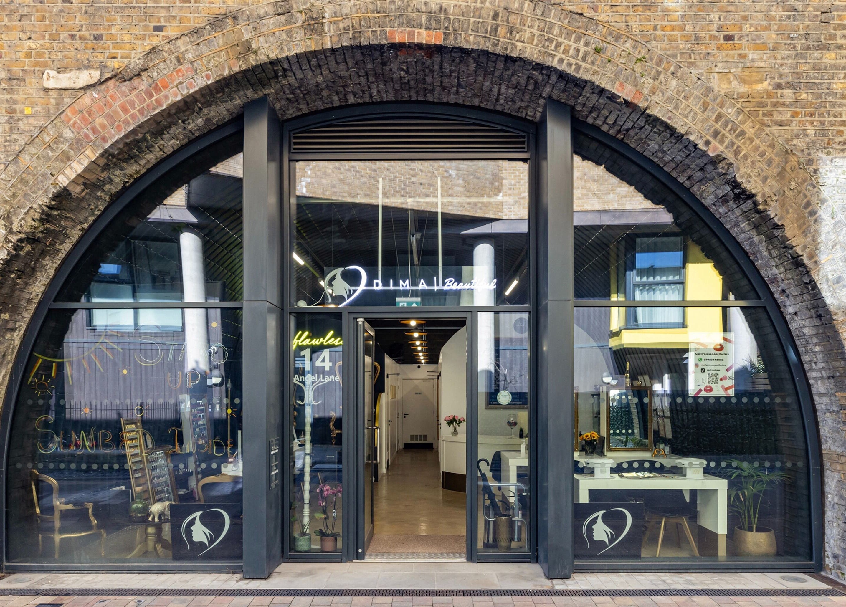 Front view of Dima Beautiful, a beauty venue in a charming brick archway in London, England, GB.