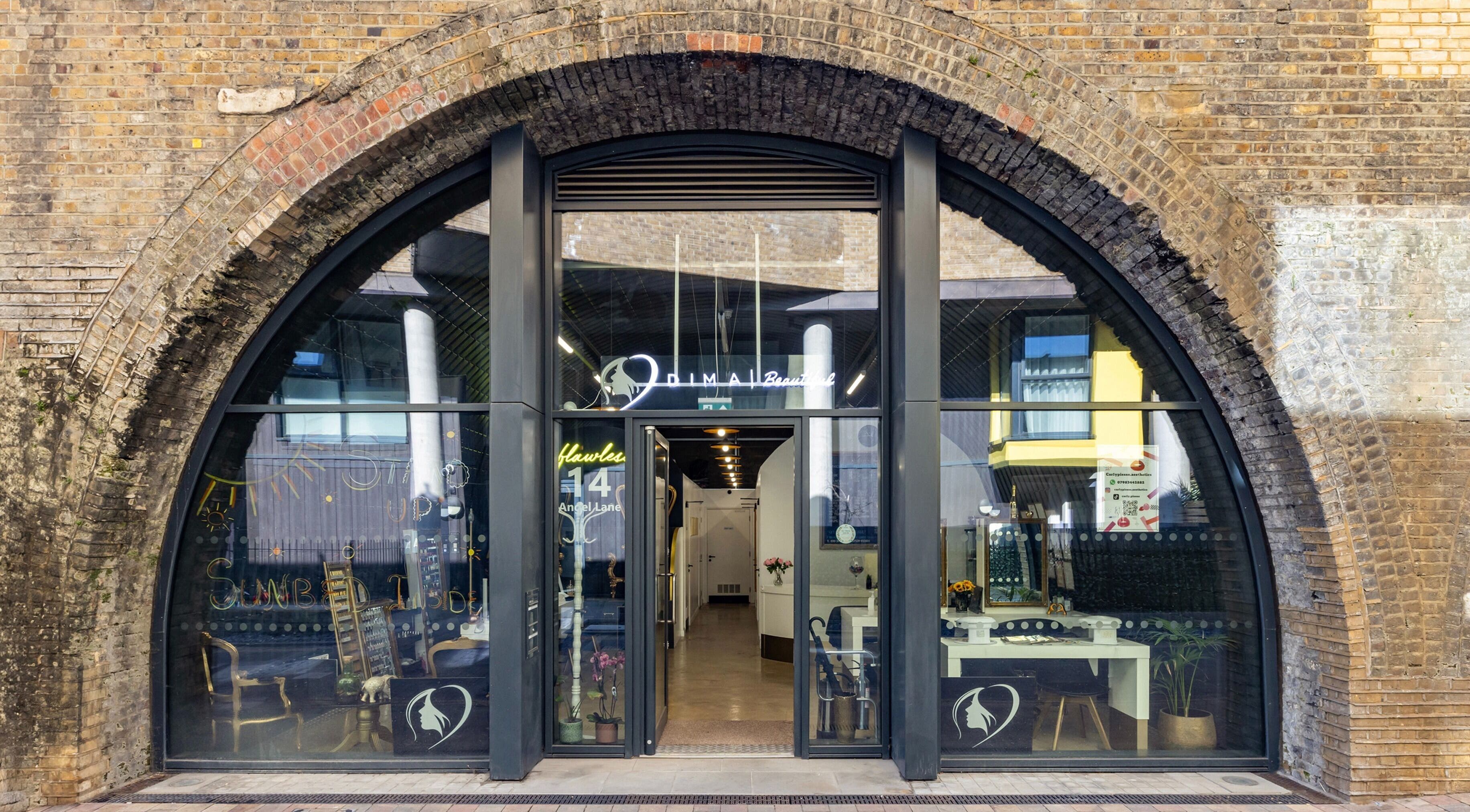Front view of Dima Beautiful, a beauty venue in a charming brick archway in London, England, GB.