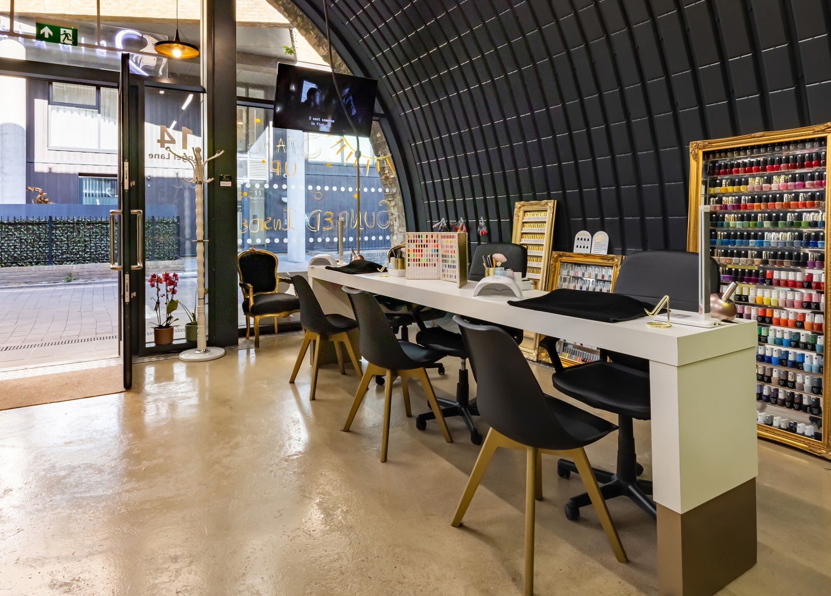 Modern nail salon interior at Dima Beautiful, London, England, GB, showcasing nail colors and chic design.