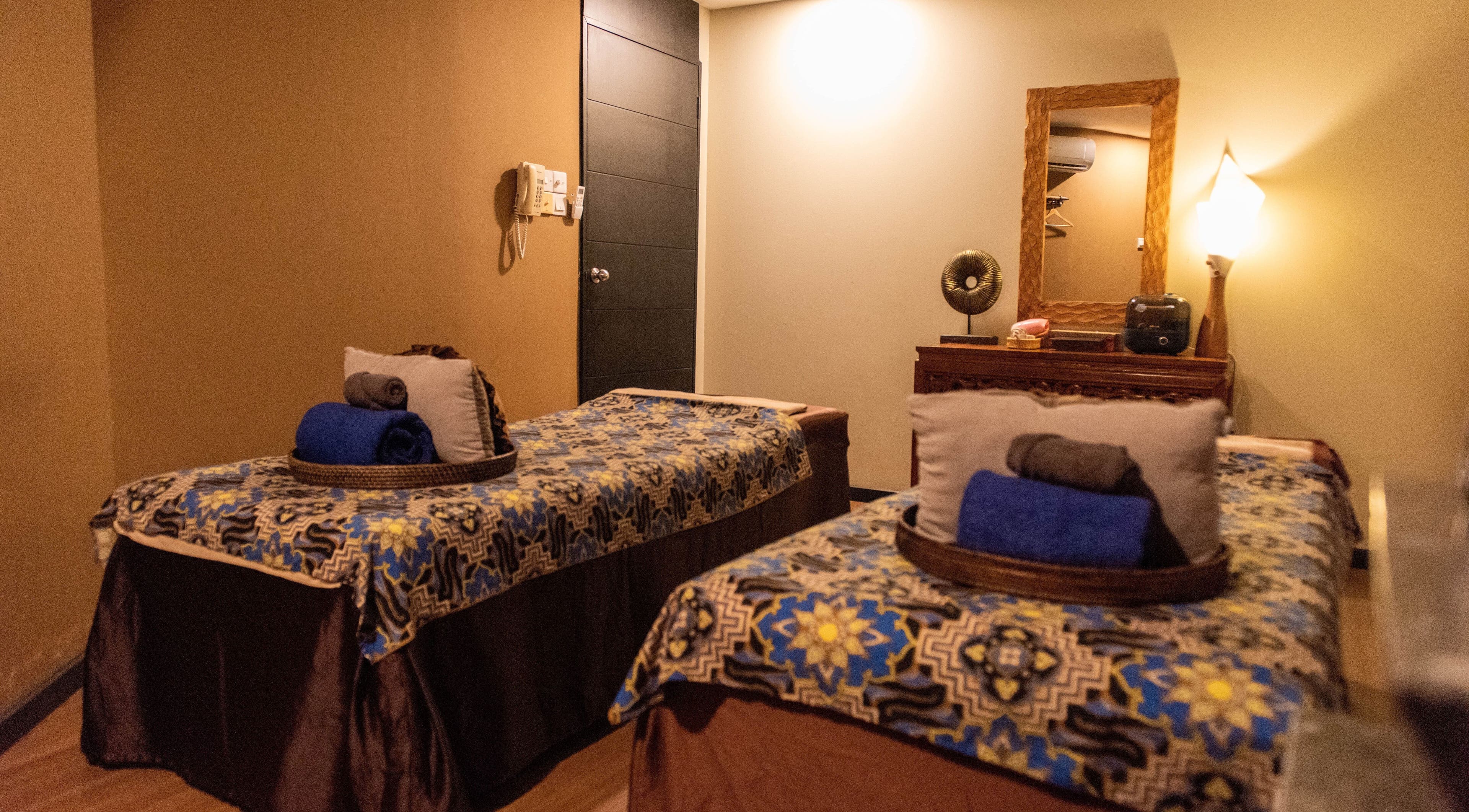 Relaxing massage room at Midas Wellness & Spa, Kota Kinabalu, Sabah, MY, featuring double beds and soft lighting.