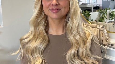 Blonde hair extensions styled in loose waves at AIM Hair Extensions, Kessingland, England, GB.
