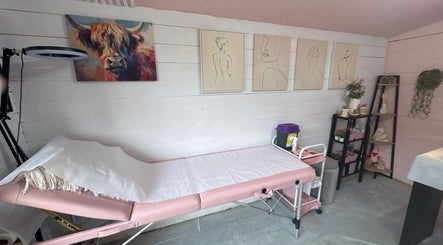 Modern treatment room at Pixie Glow Aesthetics, Harlow, England, featuring artistic wall decor and a cozy setup.