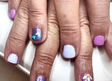 Colorful starry nail art at Pixie Glow Aesthetics, Harlow, England, GB. Vibrant purple and pink nails.