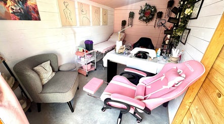 Stylish interior of Pixie Glow Aesthetics & Nails in Harlow, England, GB with pink chair and nail station.