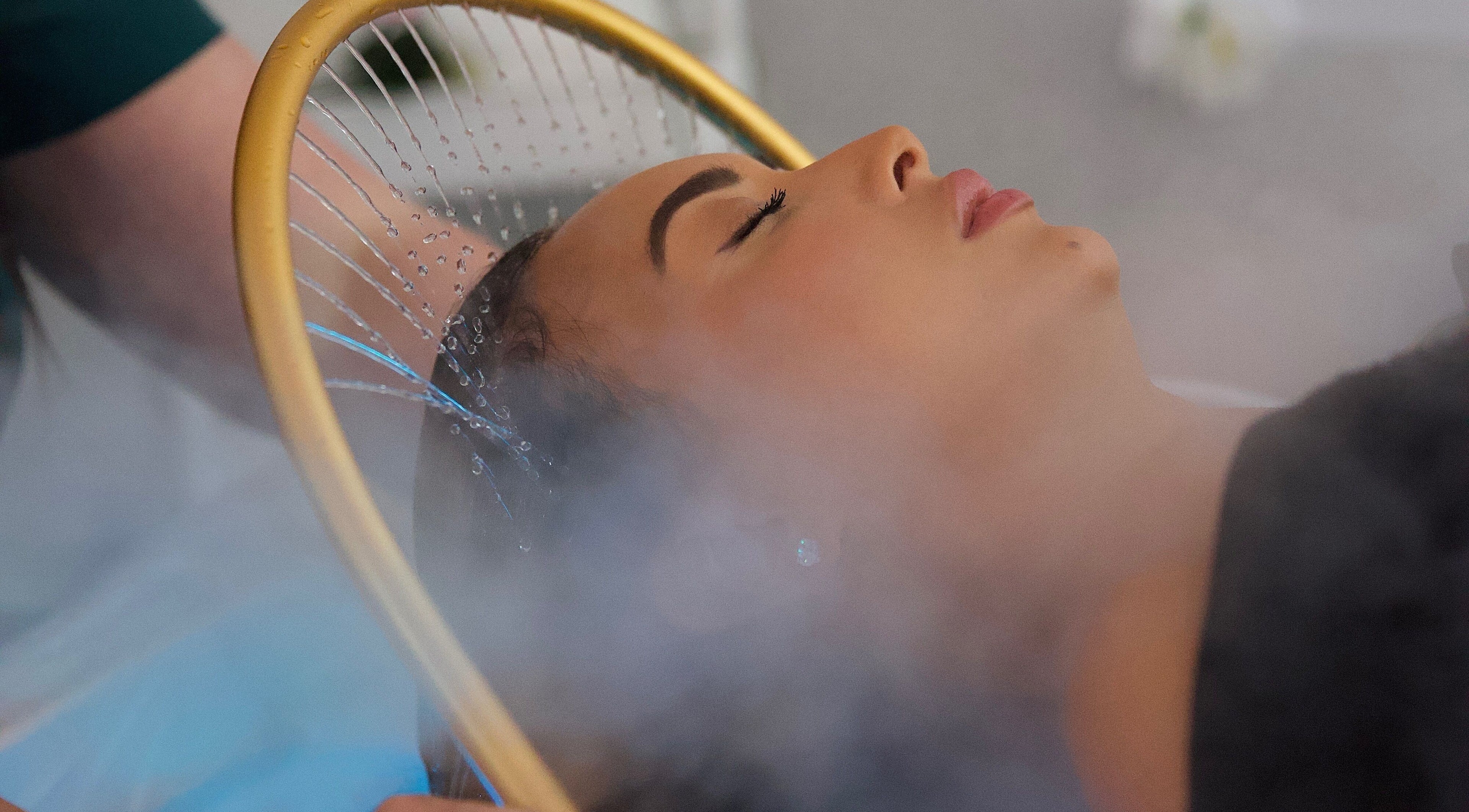 Person enjoying steam therapy at The Massage Pod in Newport, Wales, GB, with mist surrounding their face.