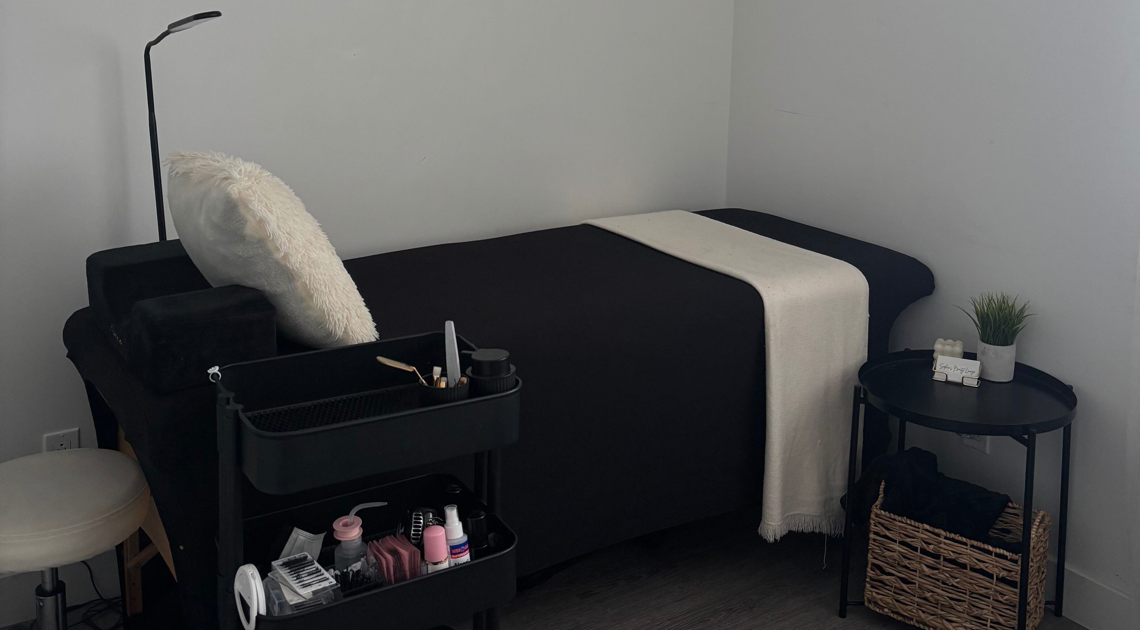 Cozy treatment bed at Sophie's Beauty Lounge in Longueuil, Québec, CA with modern decor and soft lighting.