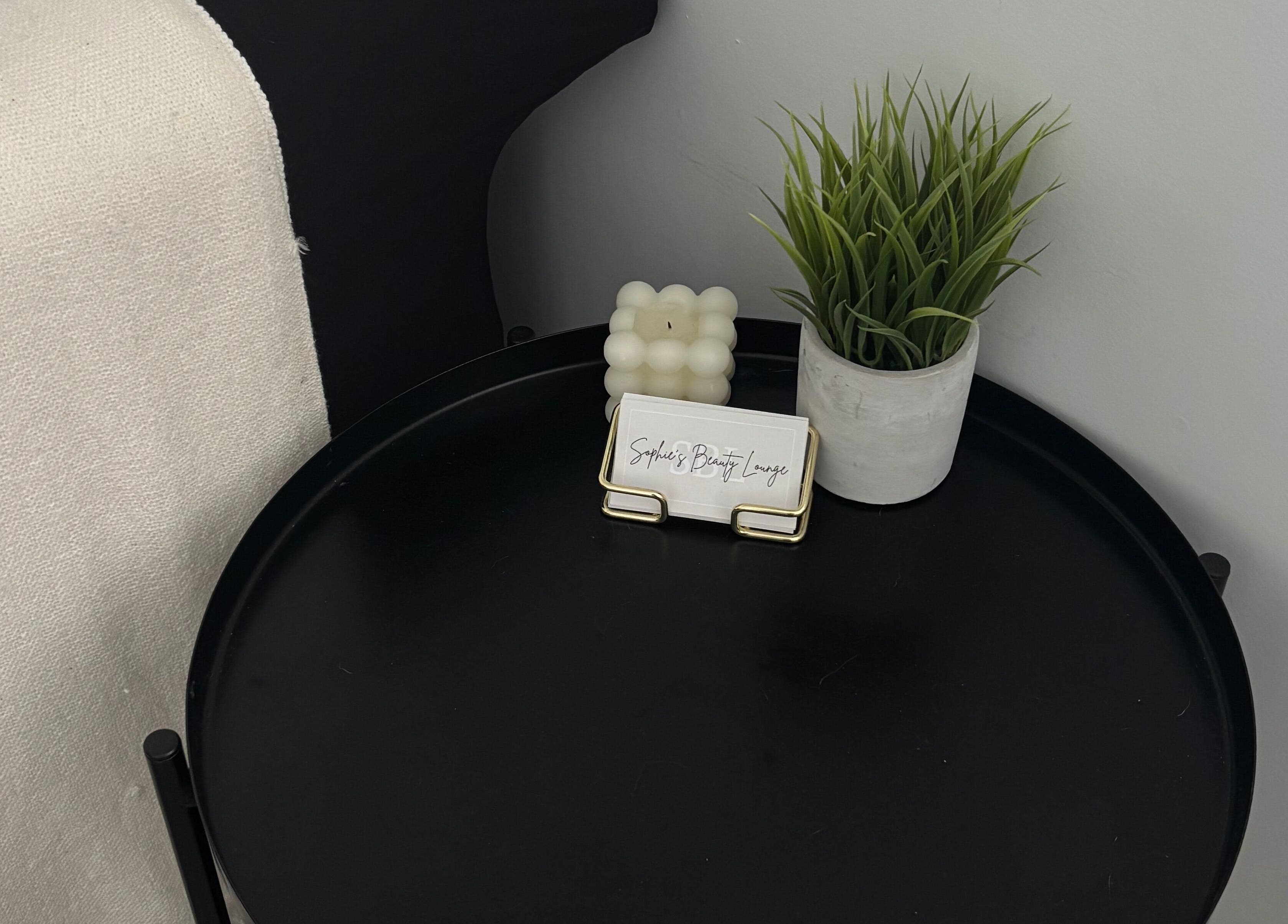 Sophie's Beauty Lounge in Longueuil, Québec, CA features a stylish table with a plant and candle.