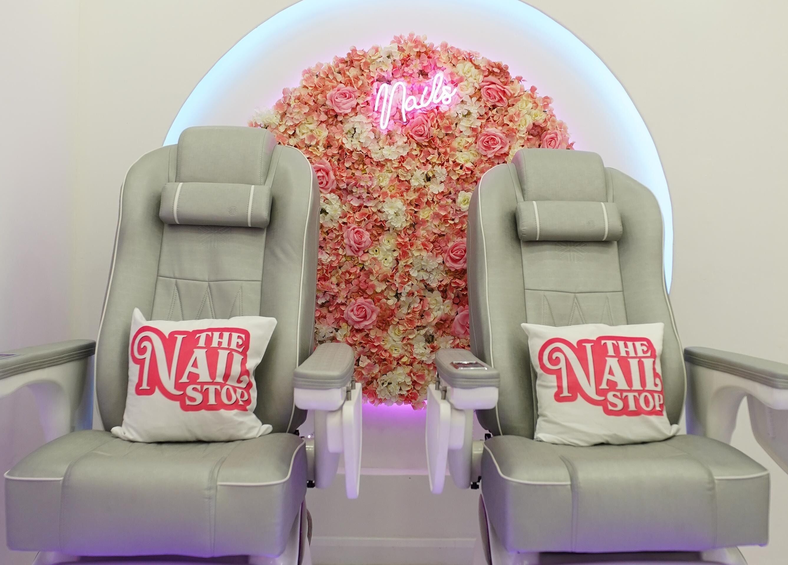 Luxurious pedicure chairs at The Nail Stop, Oldbury, England, GB, adorned with floral backdrop.