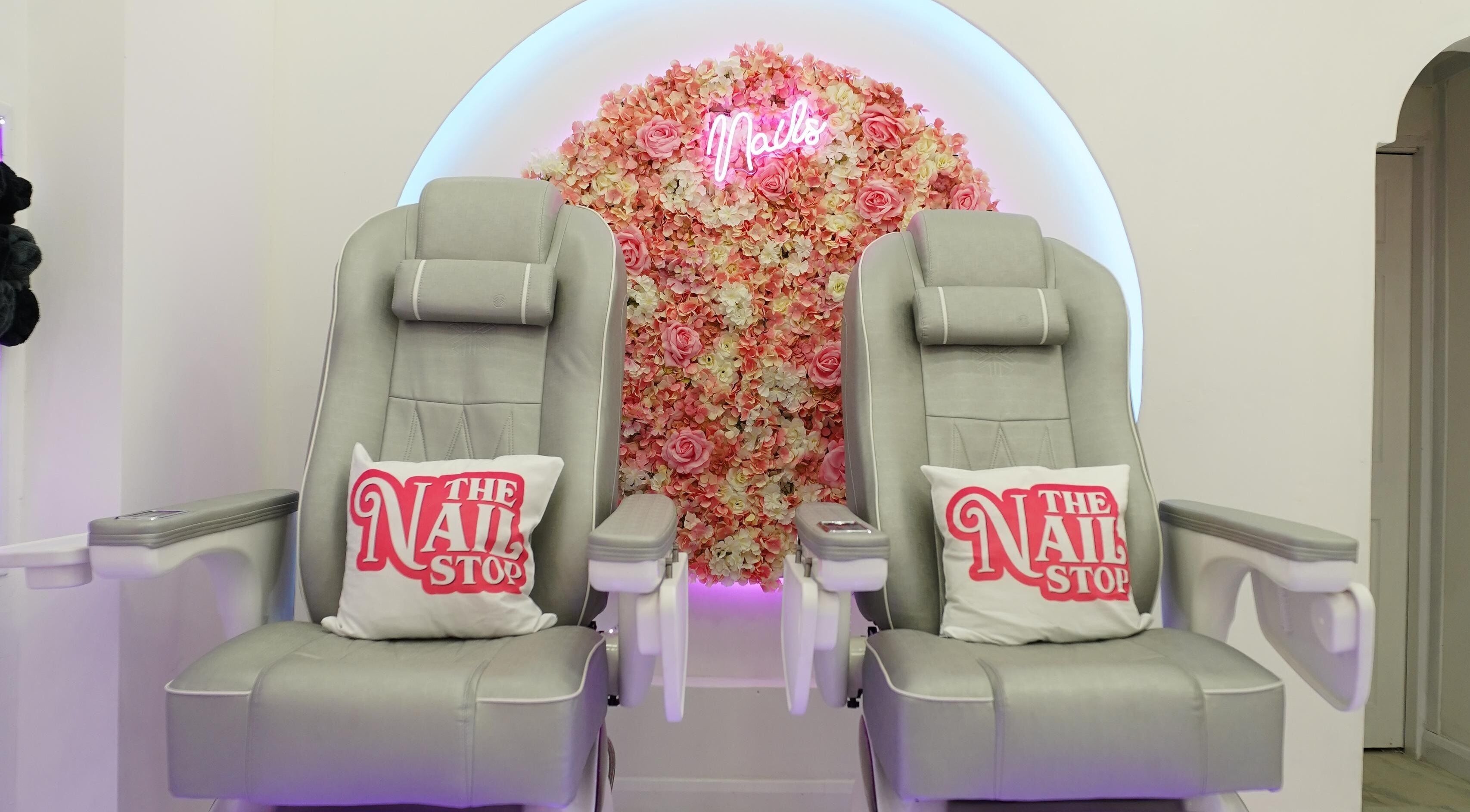 Luxurious pedicure chairs at The Nail Stop, Oldbury, England, GB, adorned with floral backdrop.