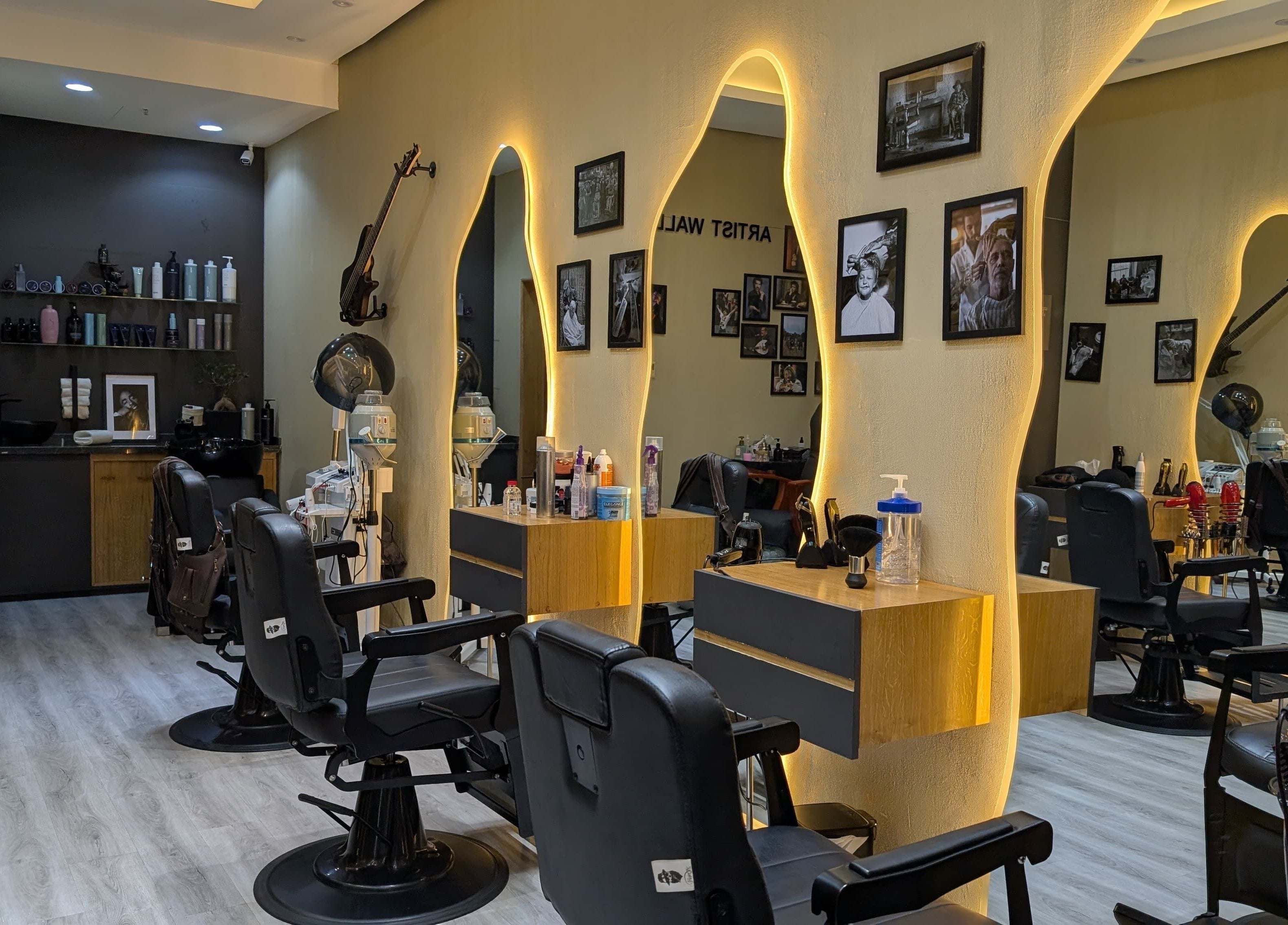 Modern interior of Bab Al Rayyan Gents Salon, Dubai, AE with stylish chairs and illuminated mirrors.