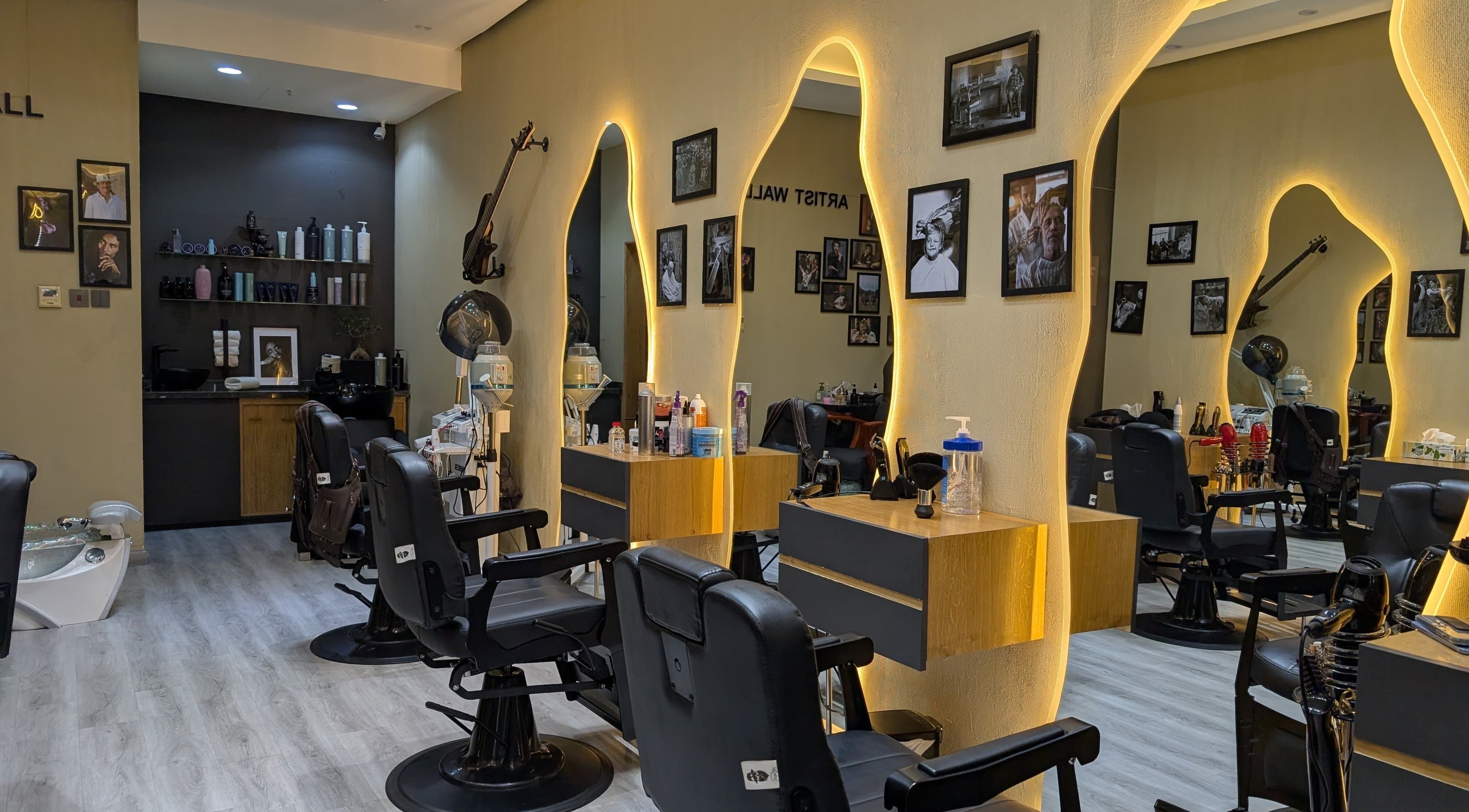 Modern interior of Bab Al Rayyan Gents Salon, Dubai, AE with stylish chairs and illuminated mirrors.