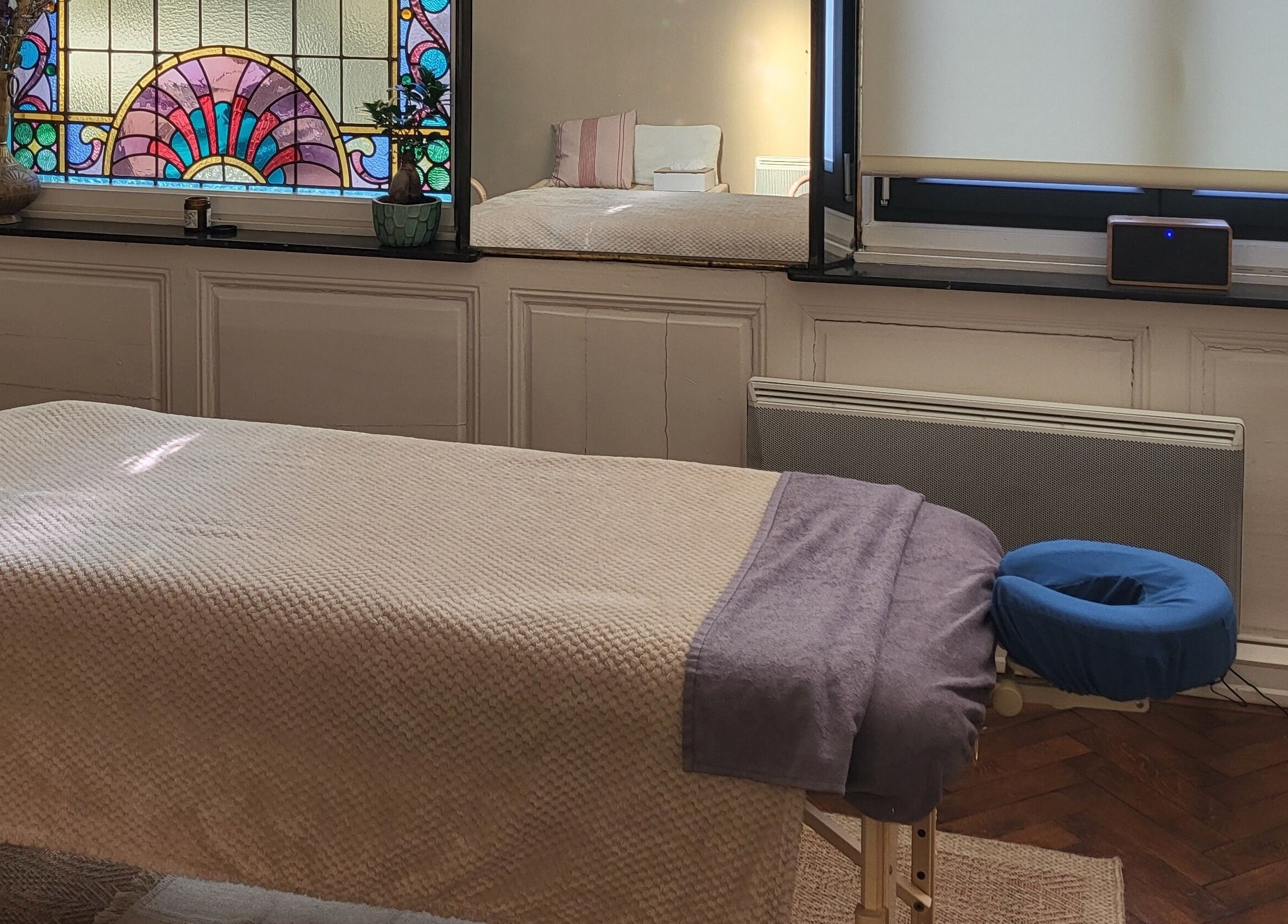 Salle de massage paisible à L'harmonie En Vous, Dunkerque, Hauts-de-France, FR avec vitrail coloré.