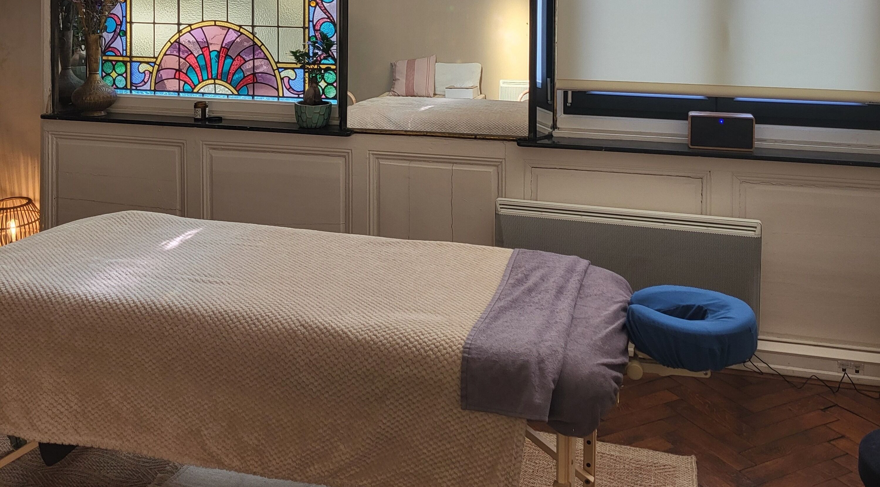 Salle de massage paisible à L'harmonie En Vous, Dunkerque, Hauts-de-France, FR avec vitrail coloré.