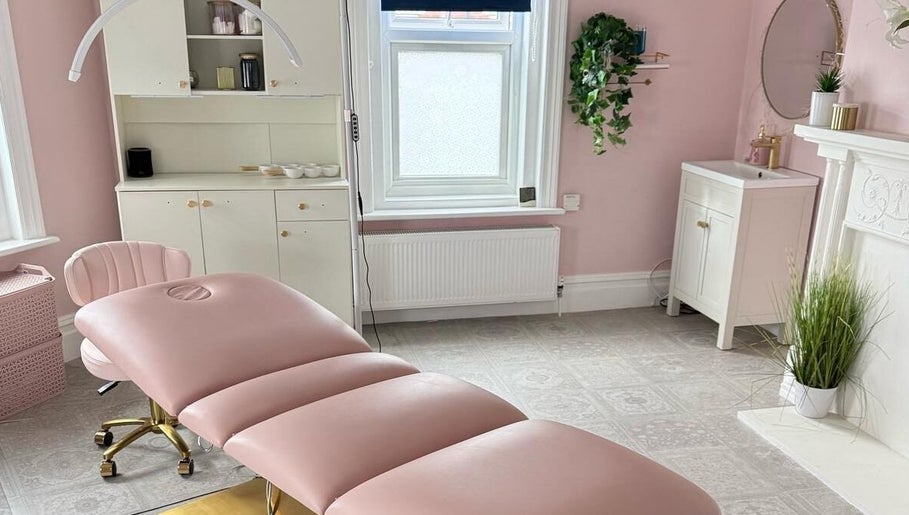 Elegant treatment room at Sea View Beauty, Poole, England, GB with pink decor and comfortable spa bed.