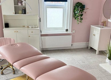 Elegant treatment room at Sea View Beauty, Poole, England, GB with pink decor and comfortable spa bed.