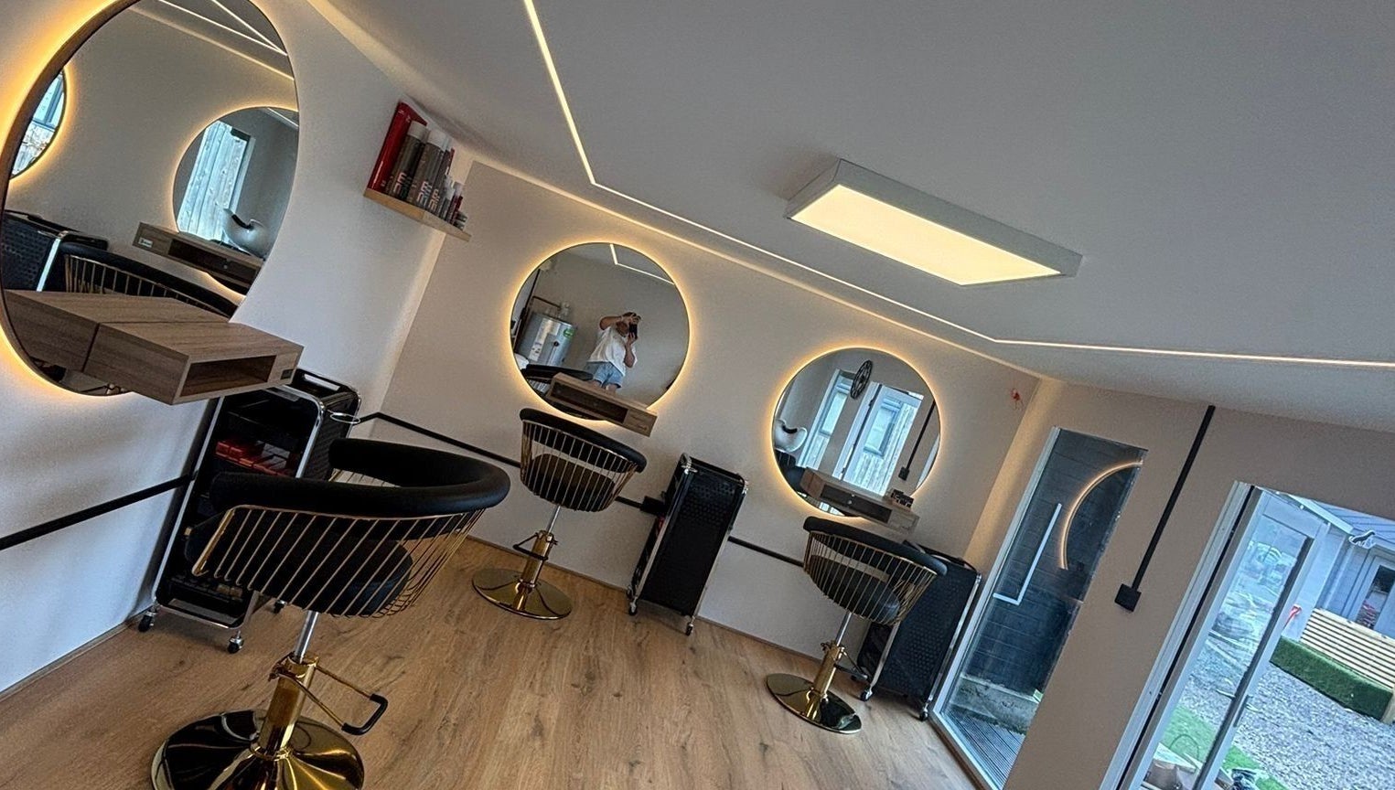 Stylish salon setup at RML Studios, Brentwood, England, GB featuring modern round mirrors and sleek chairs.