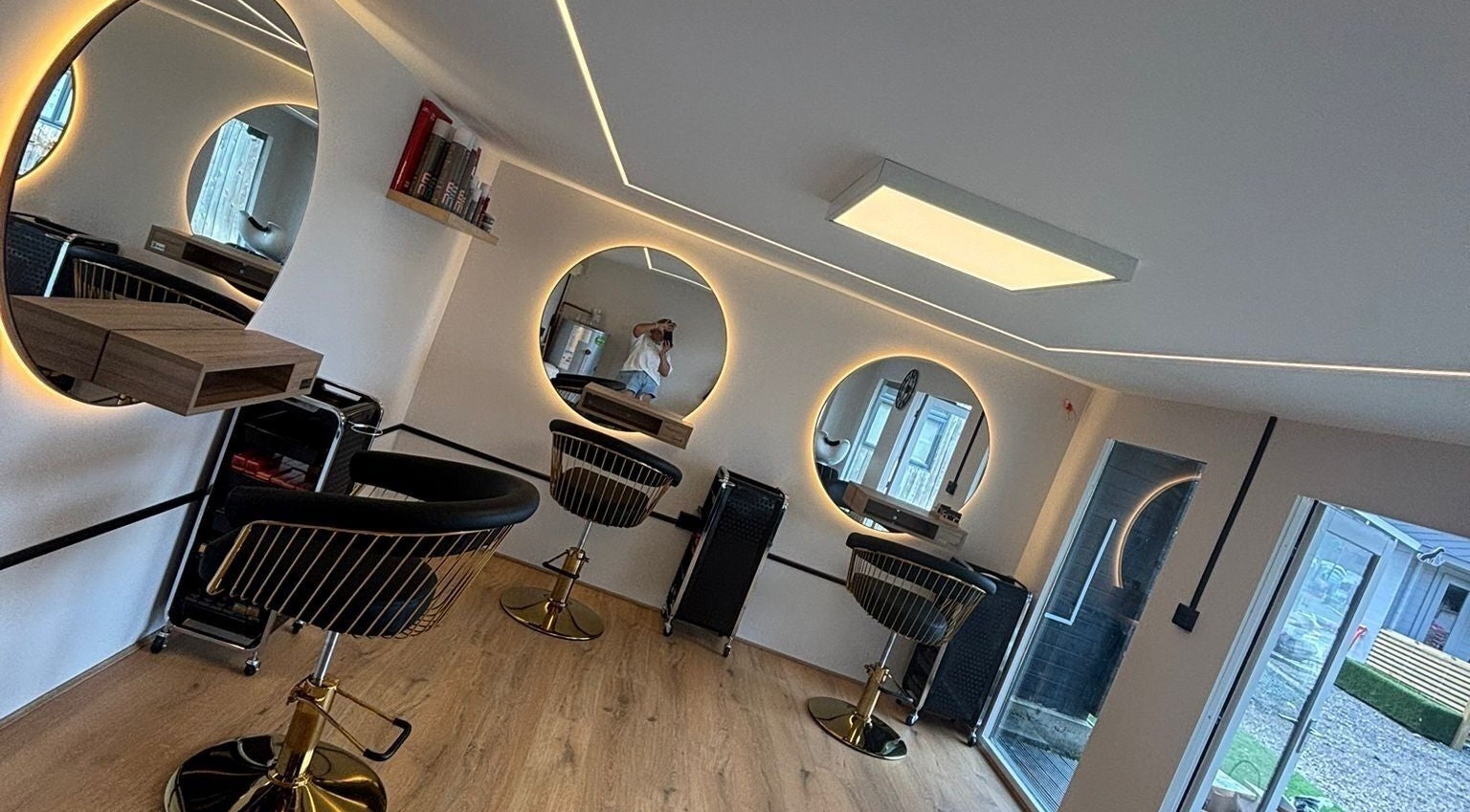 Stylish salon setup at RML Studios, Brentwood, England, GB featuring modern round mirrors and sleek chairs.