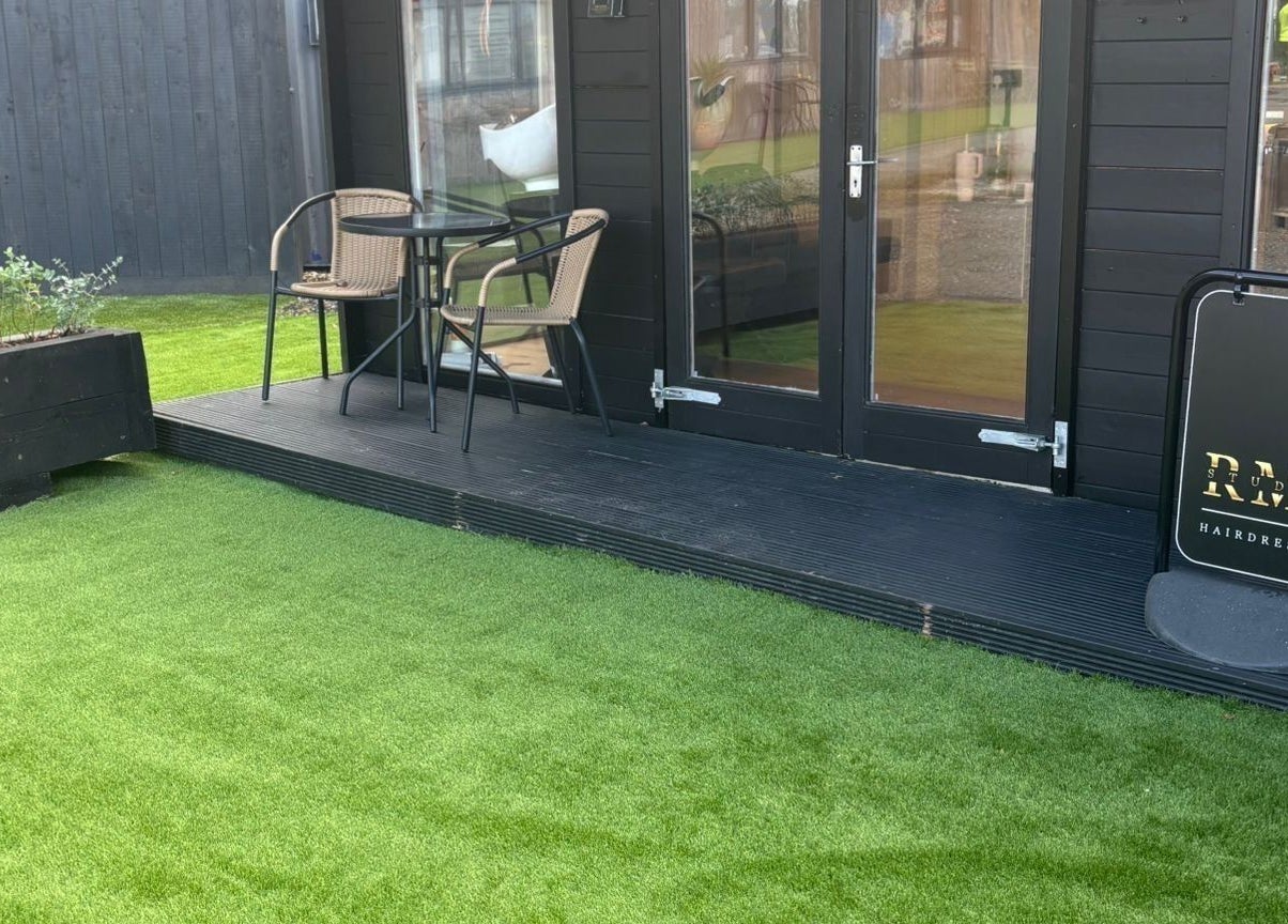 Outdoor seating and RML Studios sign at Brentwood, England, GB, on a lush green lawn.