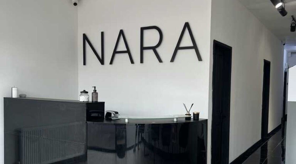 Modern reception area at INNAAMI Beauty, Halesowen, England, GB with sleek black counter and minimal decor.