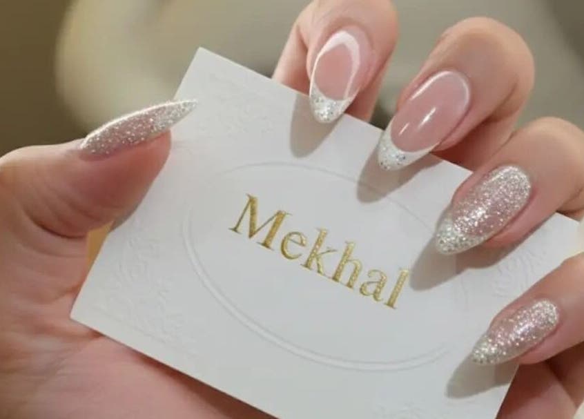 Stylish glitter nails holding صالون مكحال card in Riyadh, Riyadh Province, SA.