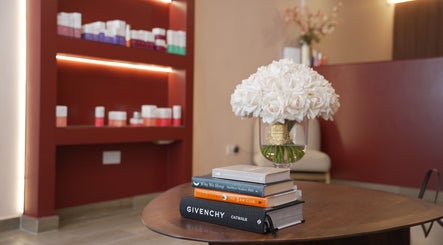 Elegant interior of Penelope Gomes Beauty, Il-gżira, MT with white flowers and luxury books on a table.