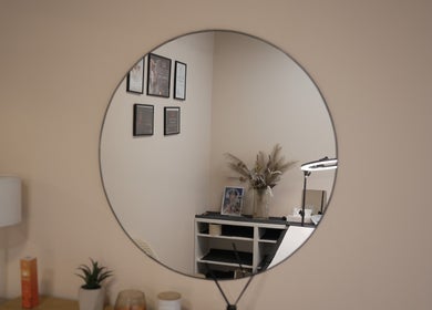 Elegant salon mirror at Penelope Gomes Beauty, Il-gżira, MT, reflecting a serene decor and stylish certificates.