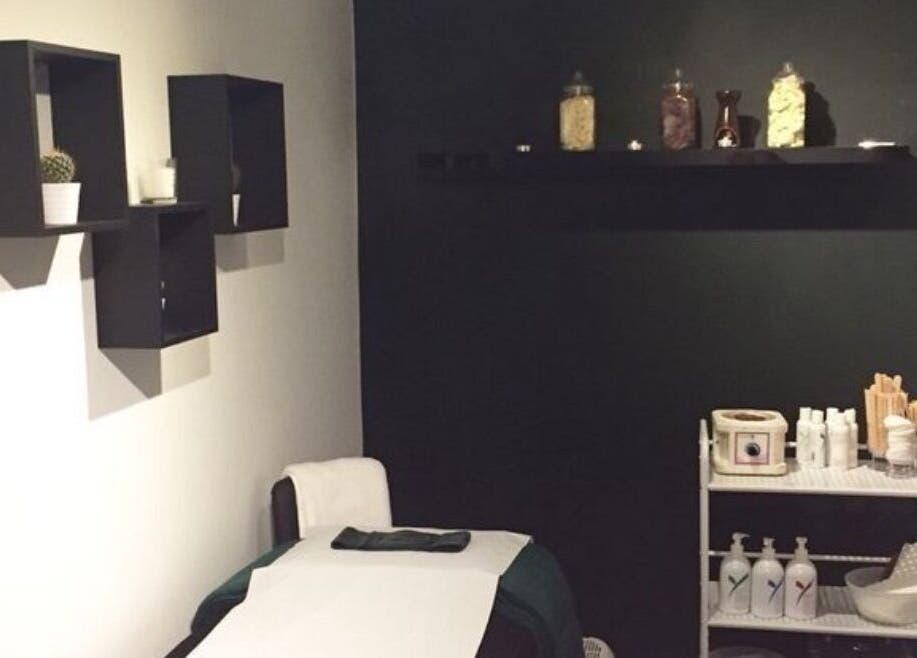 Treatment room at The Lash Alchemist in Montego Bay, St. James Parish, JM with a bed and shelves.