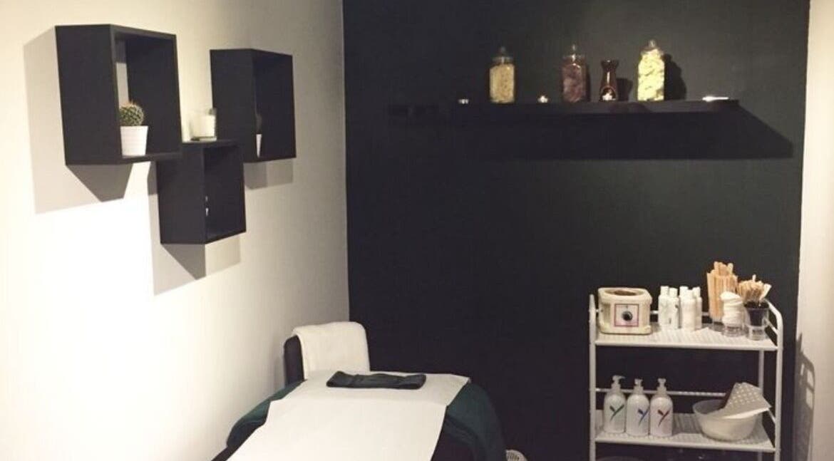 Treatment room at The Lash Alchemist in Montego Bay, St. James Parish, JM with a bed and shelves.