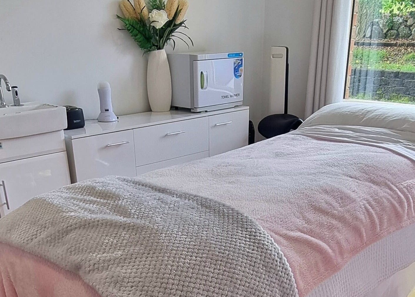 Relaxing treatment room with pink linens at FlawLiss Beauty, Cooranbong, New South Wales, AU, perfect for wellness.