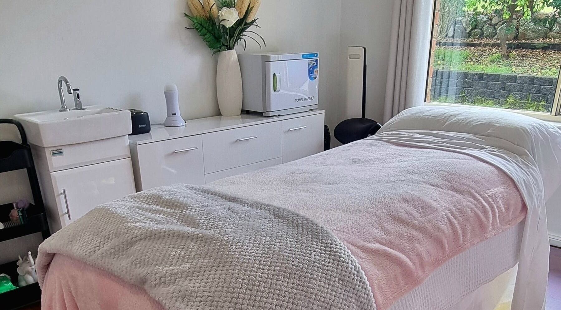 Relaxing treatment room with pink linens at FlawLiss Beauty, Cooranbong, New South Wales, AU, perfect for wellness.