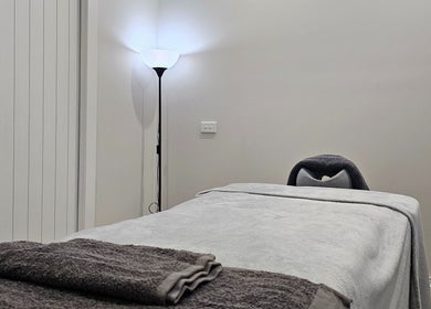 Relaxing massage room at Qi Harmony Massage, Normanby, Taranaki, NZ, featuring a cozy massage table and ambient light.