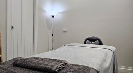 Relaxing massage room at Qi Harmony Massage, Normanby, Taranaki, NZ, featuring a cozy massage table and ambient light.