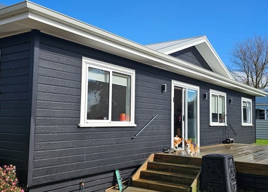 Modern building exterior at Qi Harmony Massage, Normanby, Taranaki, NZ, showcasing a serene wooden deck.