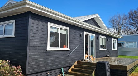 Modern building exterior at Qi Harmony Massage, Normanby, Taranaki, NZ, showcasing a serene wooden deck.