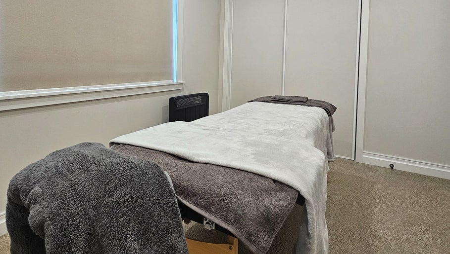 Cozy massage room at Qi Harmony Massage, Normanby, Taranaki, NZ with soft blankets and calming decor.