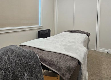 Cozy massage room at Qi Harmony Massage, Normanby, Taranaki, NZ with soft blankets and calming decor.