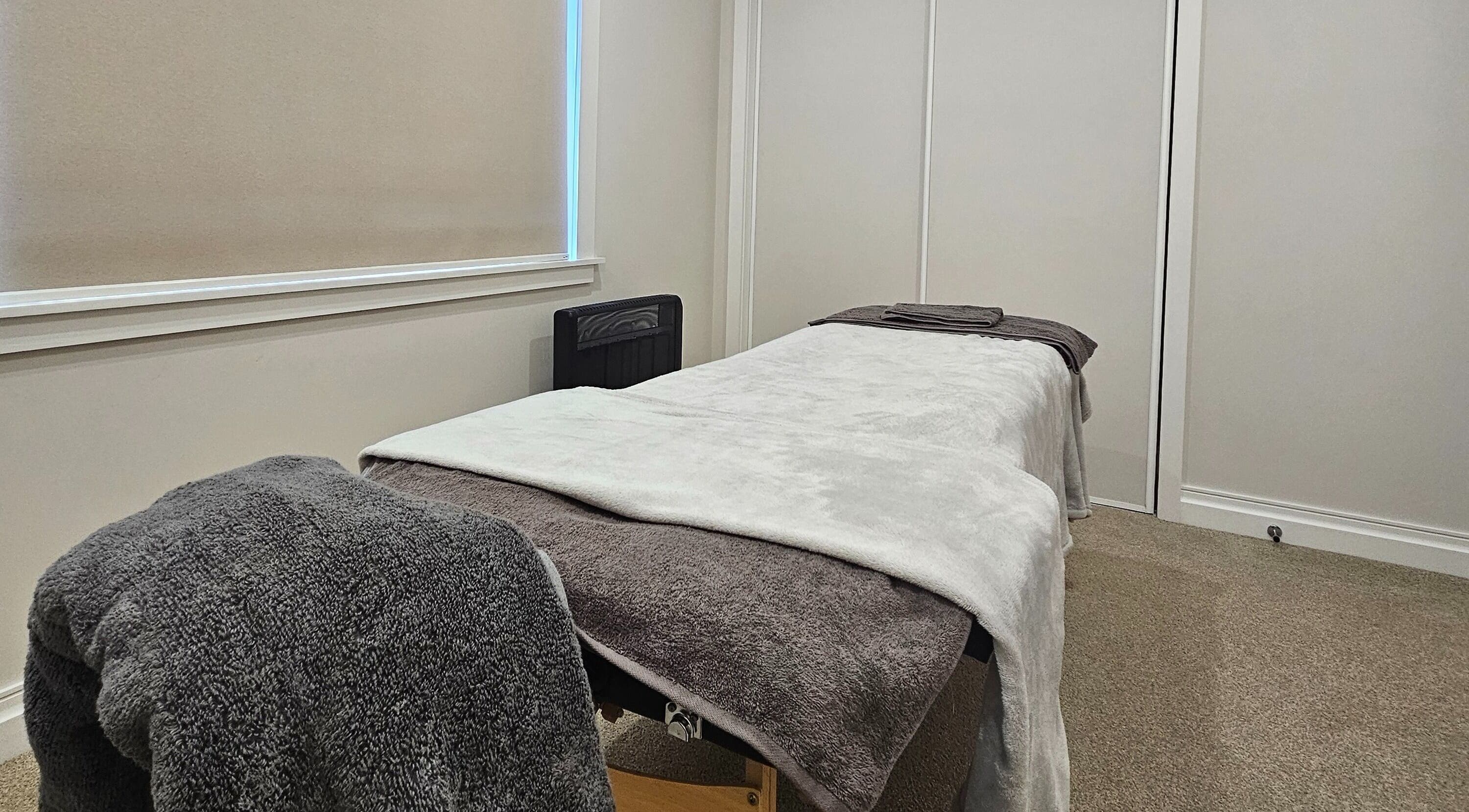 Tranquil massage room at Qi Harmony Massage, Eltham, Taranaki Region, NZ with cozy blankets and soft lighting.