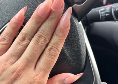 Elegant manicured nails from The Nail Bar🍸, located in Brampton, Ontario, CA, on a car steering wheel.