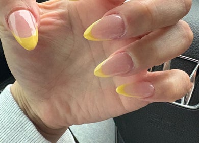 Stylish yellow-tipped nails at The Nail Bar, Brampton, Ontario, CA.