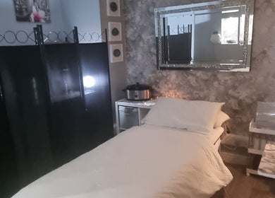 Cozy treatment room at The Healing Room Oldham, Lees, England, GB with relaxing decor and cushioned bed.