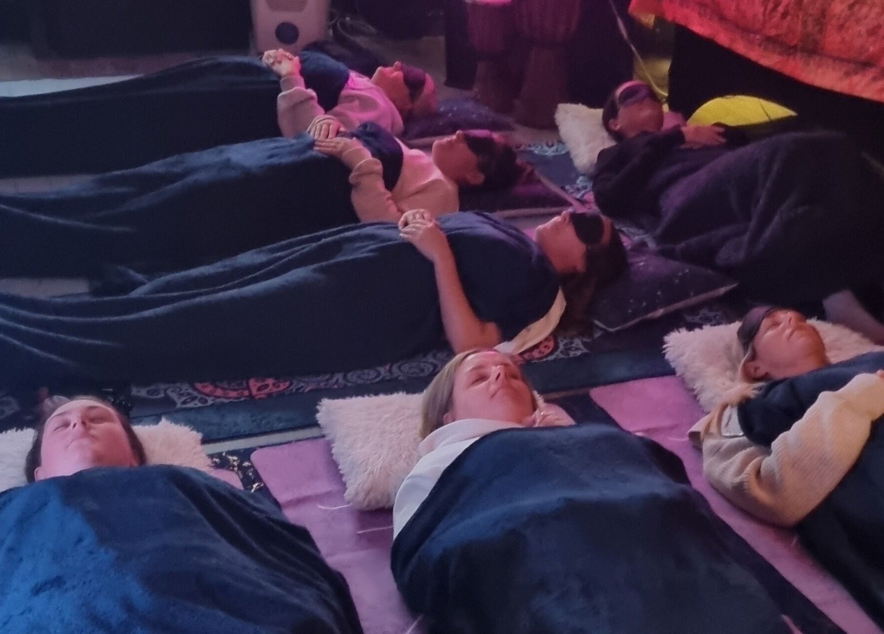 Guests relaxing under blankets at The Healing Room Oldham in Oldham, England, GB for a soothing group meditation.