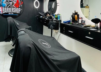 Modern interior of NBA Barbershop Bonaire in Kralendijk, showcasing sleek chairs and grooming tools.