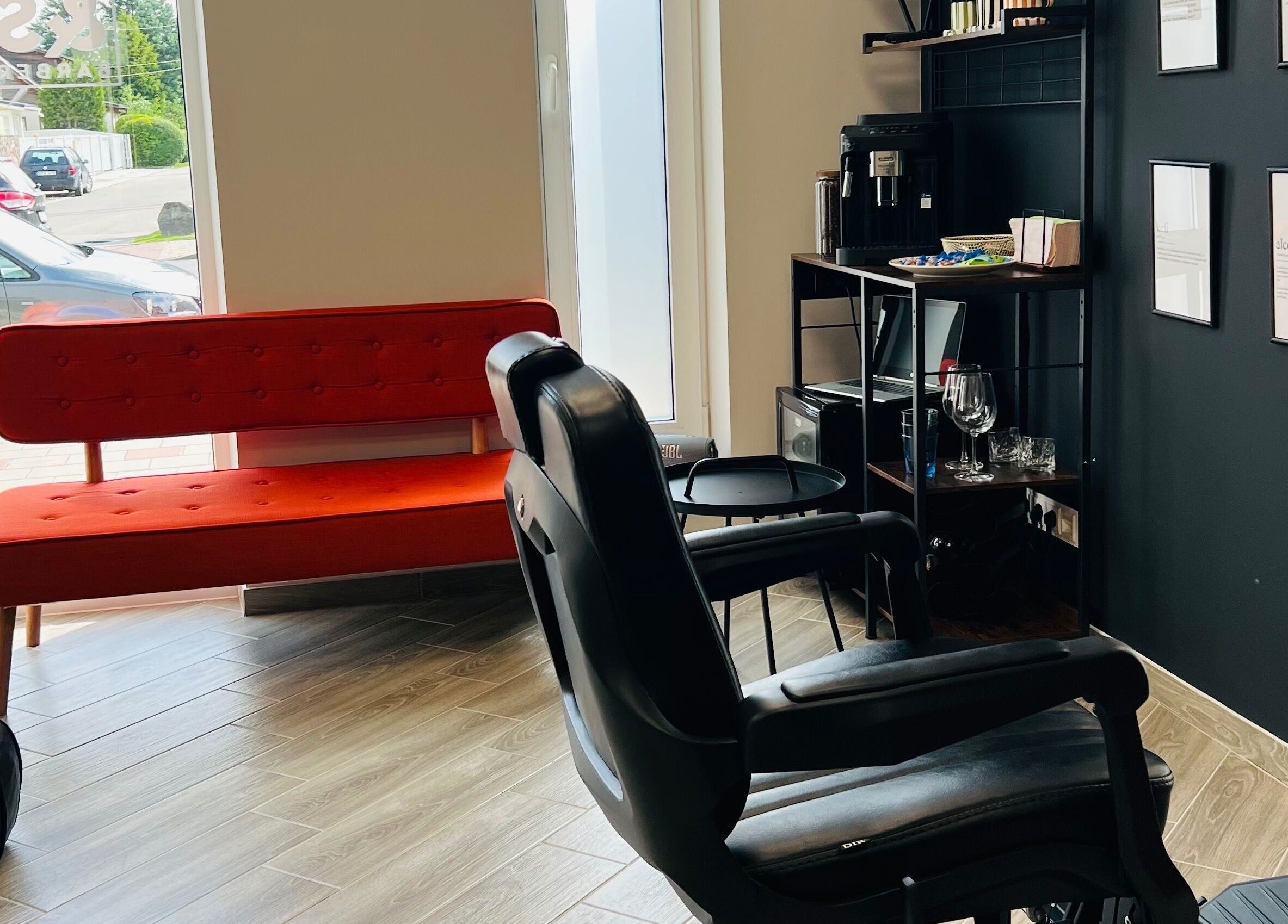 Snip&Sip Barbershop interjeras Panevėžys, Panevėžio Apskritis, LT. Moderni poilsio zona su raudona sofa.