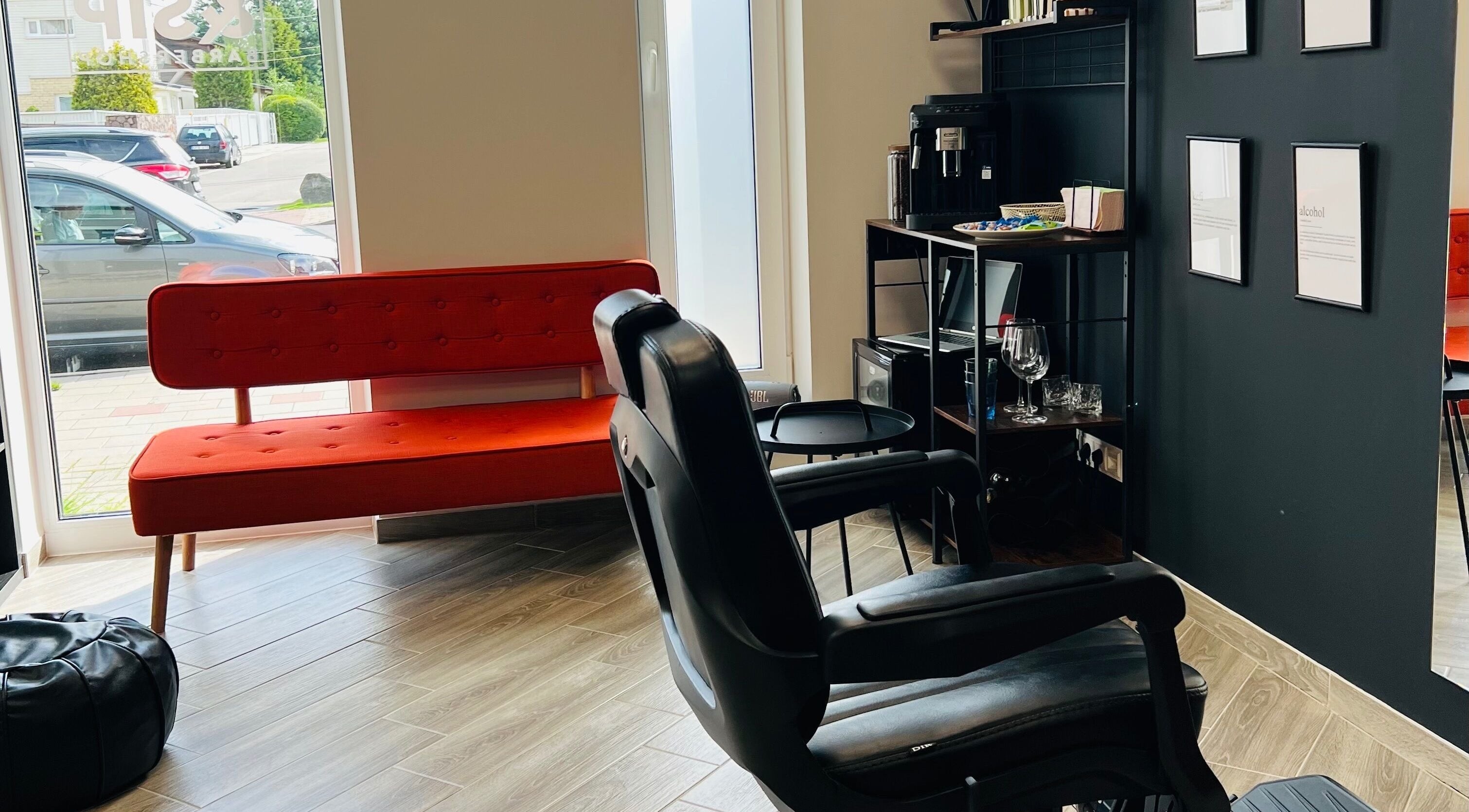 Snip&Sip Barbershop interjeras Panevėžys, Panevėžio Apskritis, LT. Moderni poilsio zona su raudona sofa.