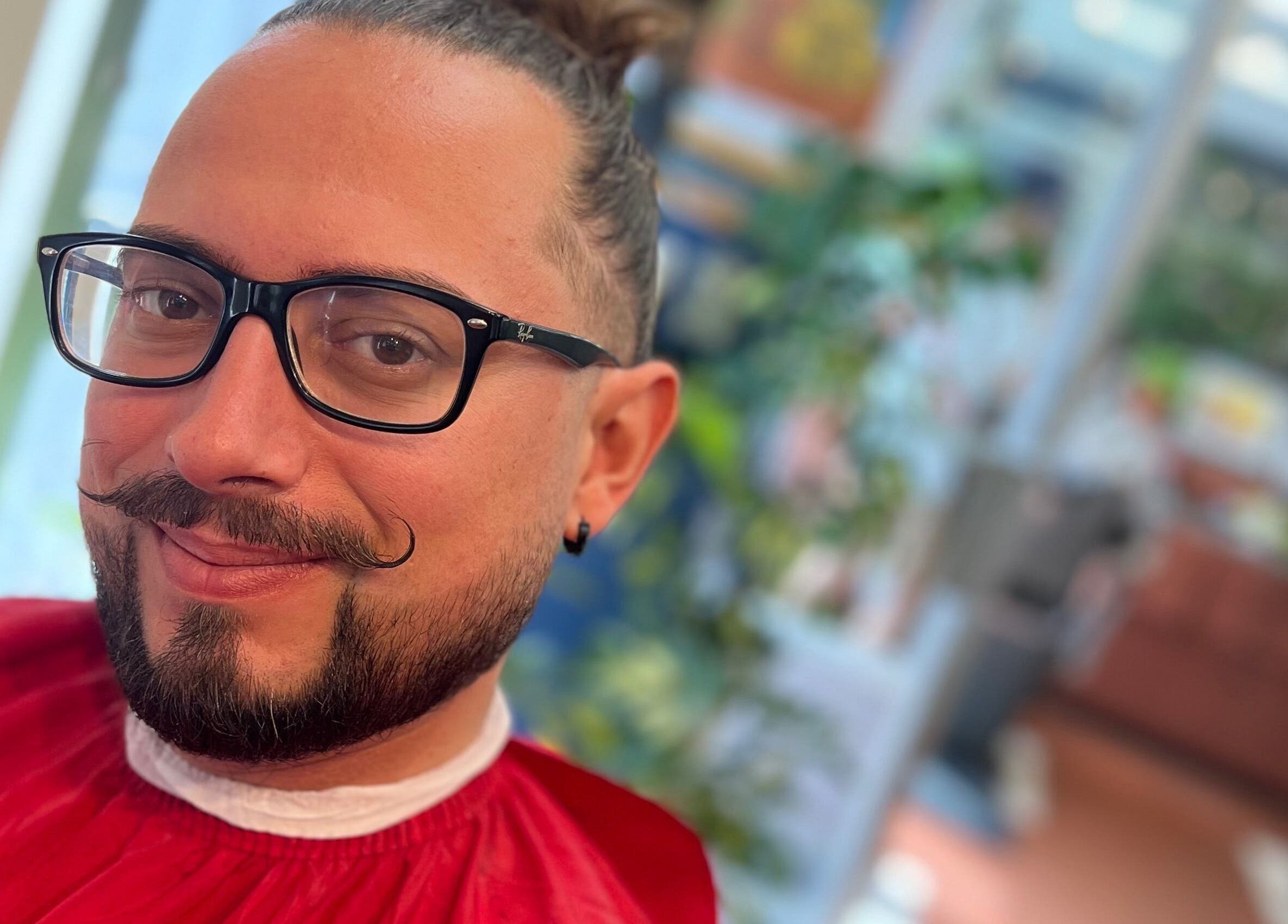 Client heureux chez Davidson Barbershop à Perpignan, Occitanie, FR, arborant une moustache élégante.