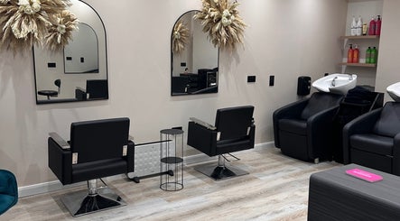 Elegant interior of THE STYLIST Hair Studio, Stockport, England, showcasing sleek salon chairs and mirrors.